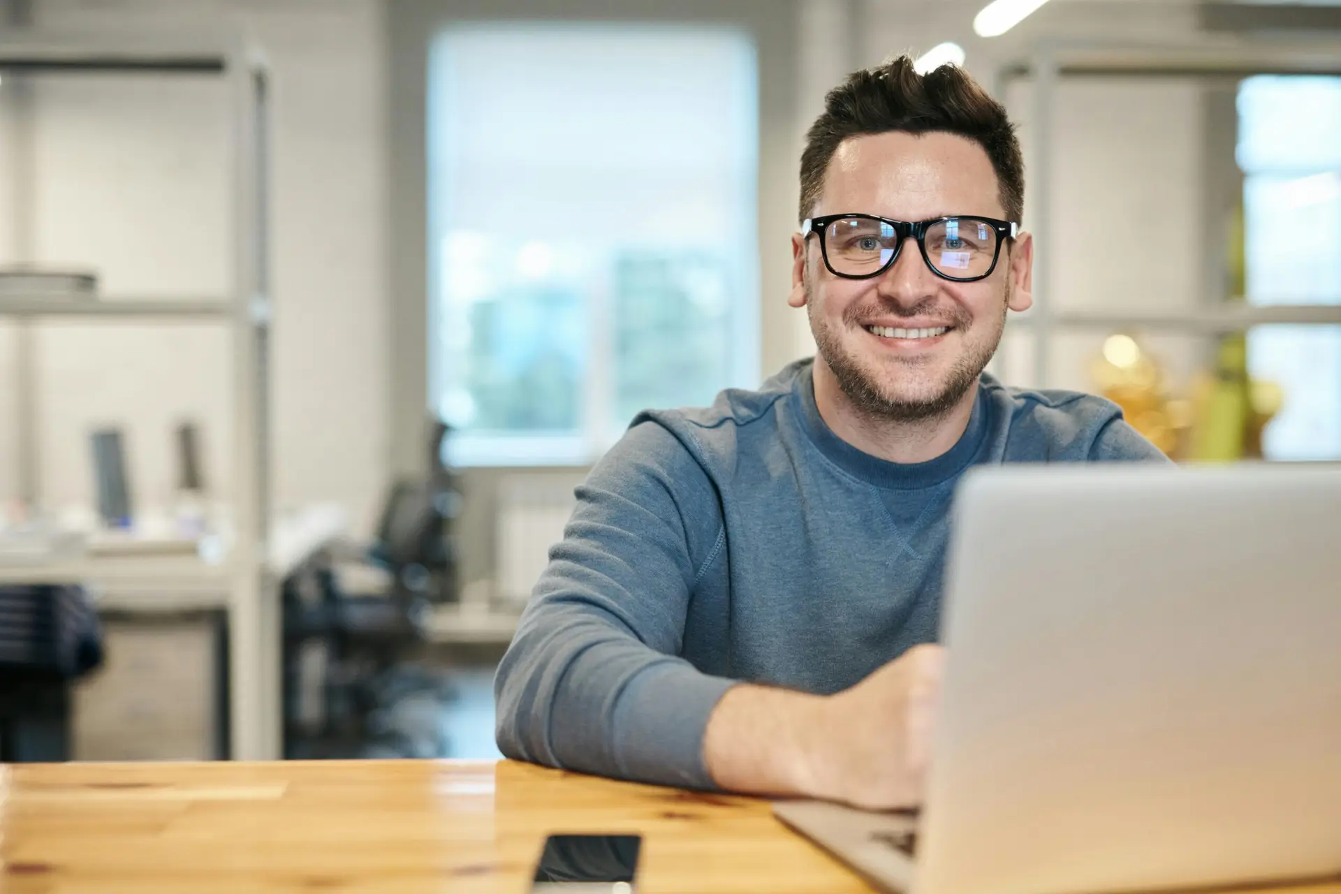 Man looking up from his computer and smiling